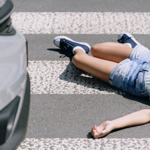 A child lying on a crosswalk after being hit by a car in a traffic accident.