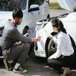 Car accident scene with drivers inspecting vehicle damage and documenting the accident in Texas.